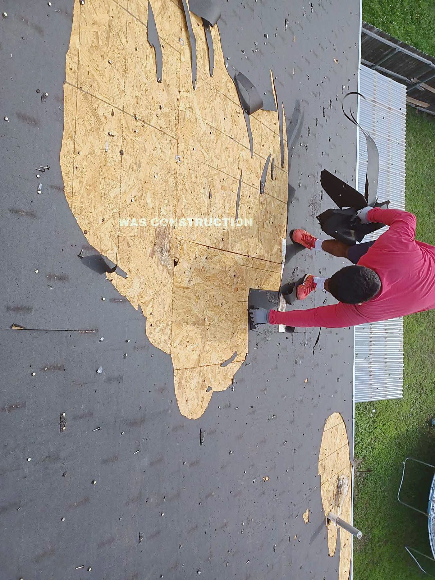 A crew member working on a stripped roof