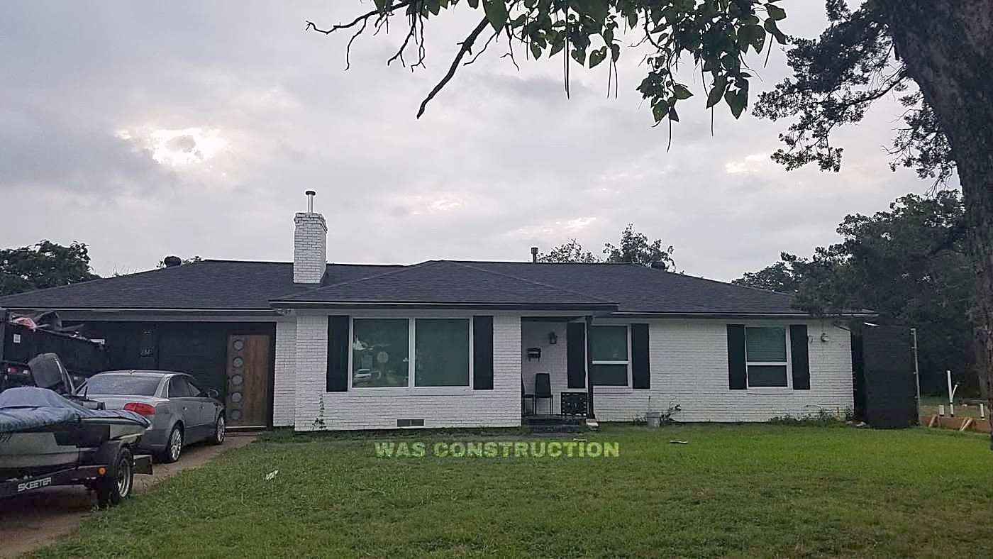 A single-story white brick home with a finished shingle roof